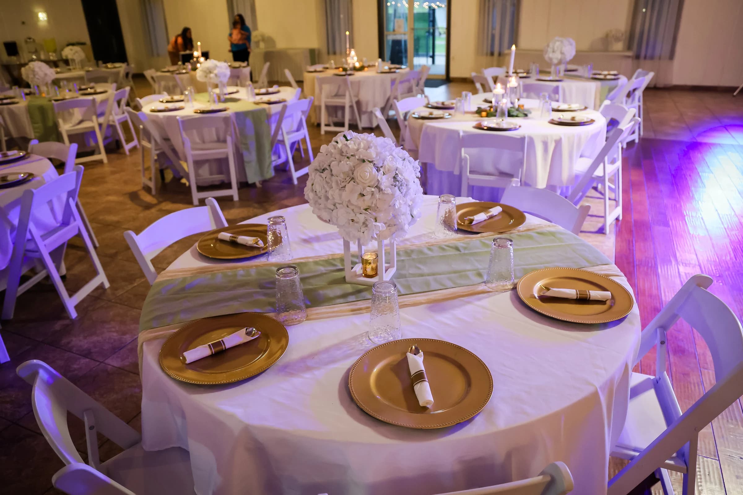 Reception tables set with white flowers and candles