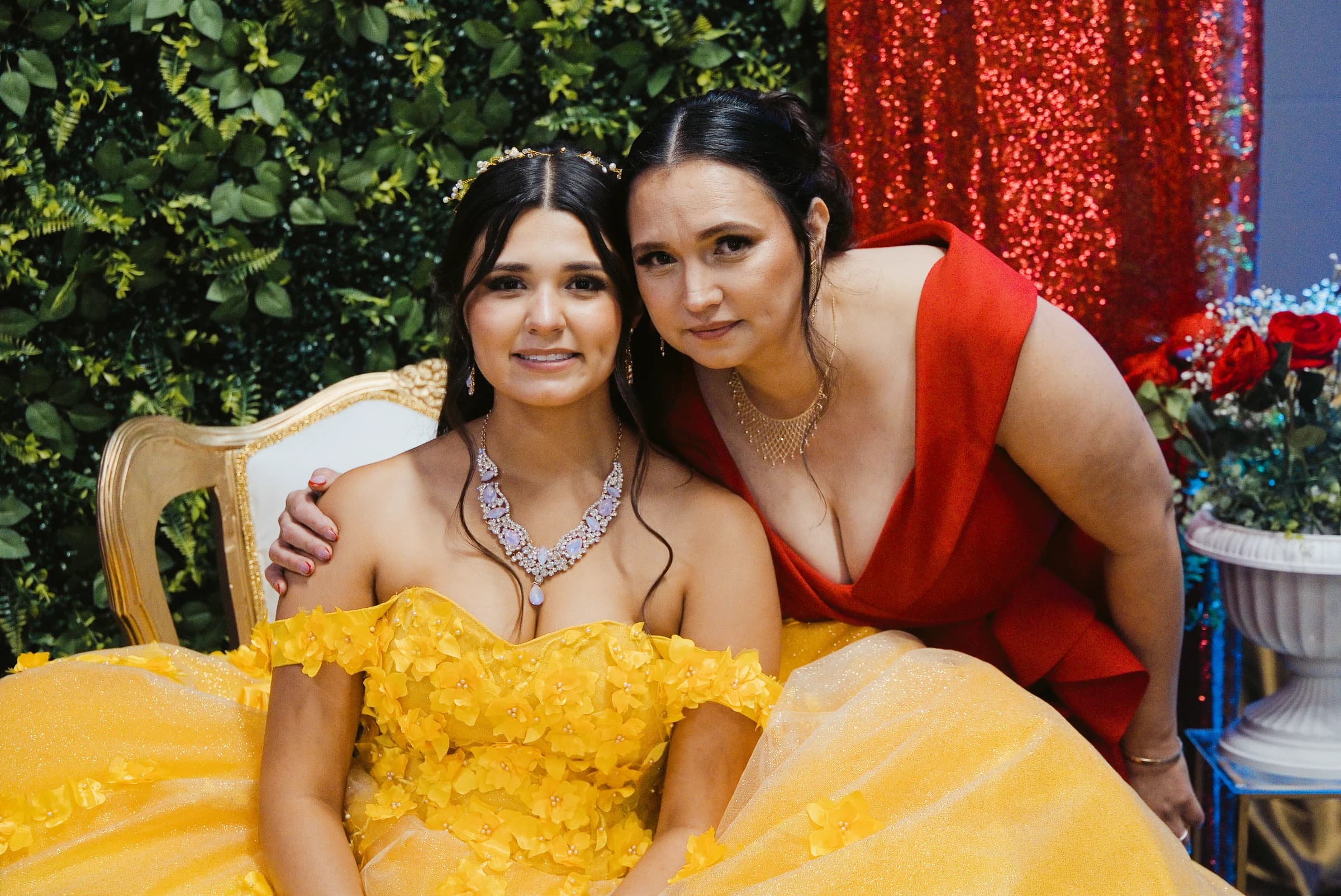 A quinceañera in a yellow gown with a family member at her celebration