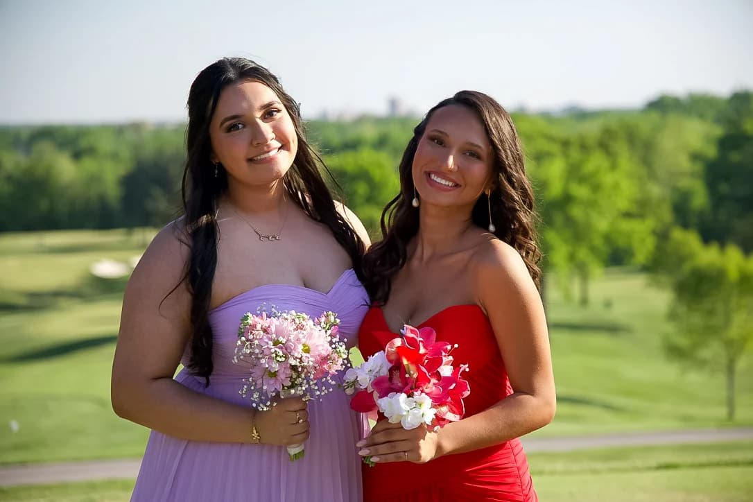 Two friends in prom dresses holding bouquets