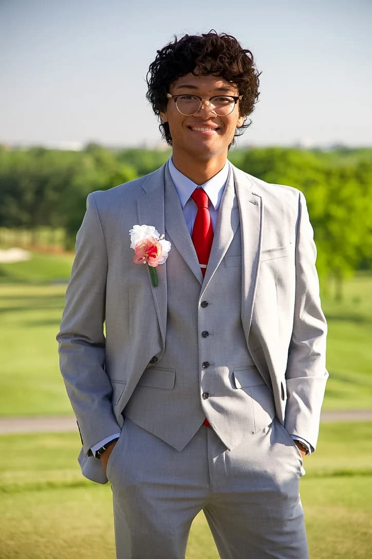 Prom portrait in a gray suit and red tie