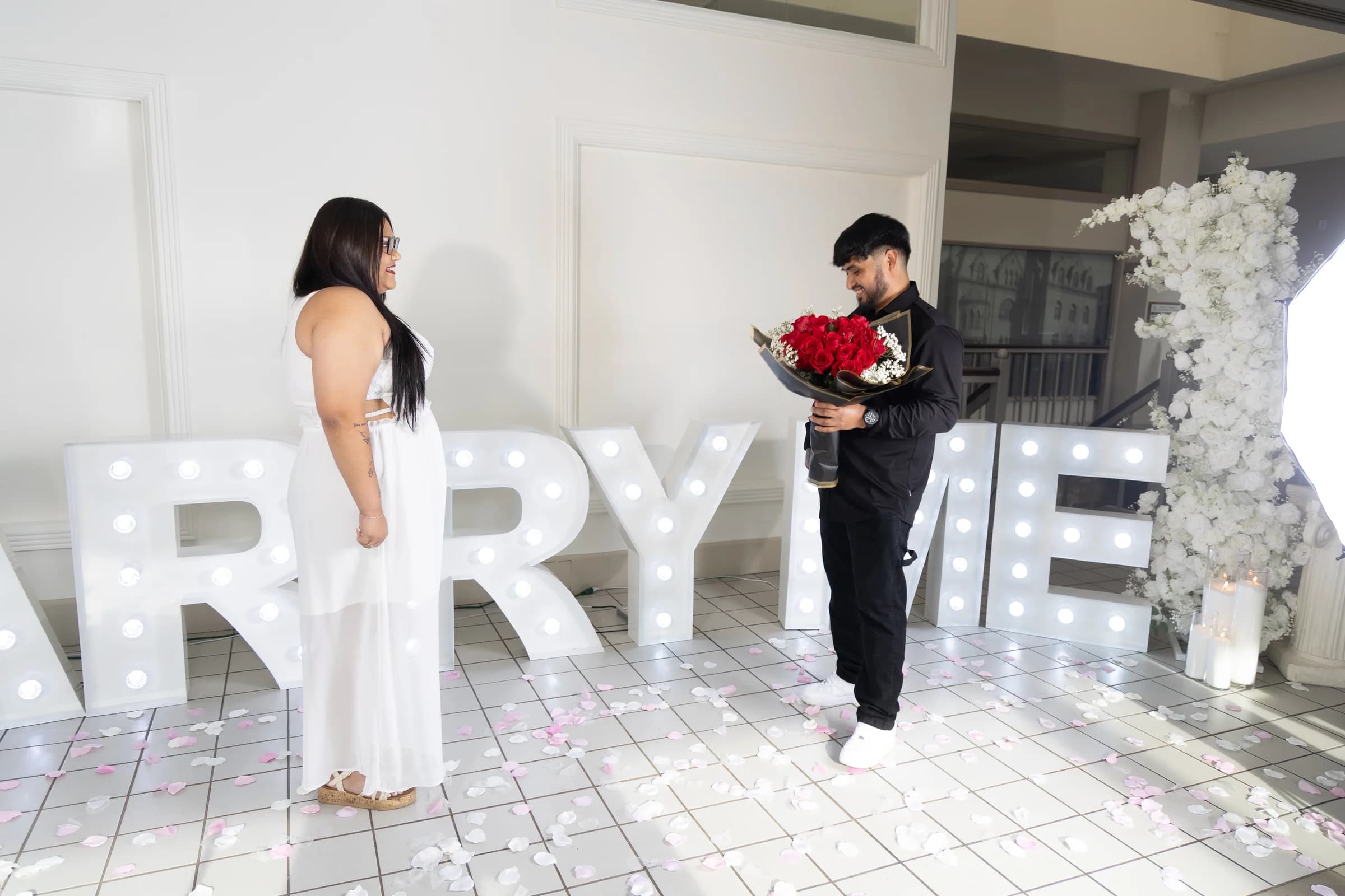 Couple facing each other with red roses during a proposal