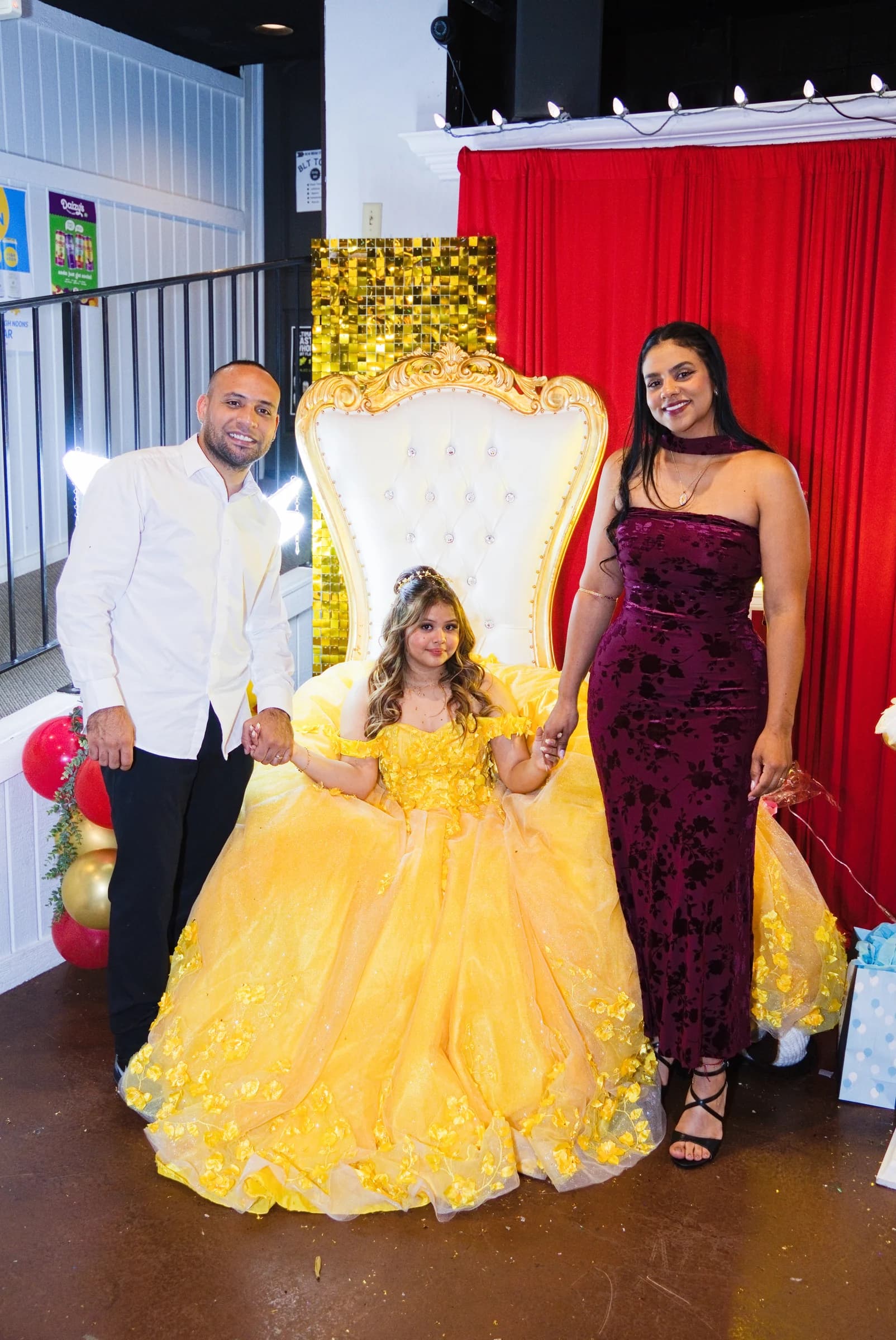 Quinceañera in a yellow gown with her family at the reception